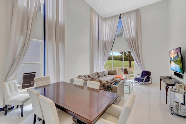 dining area featuring light tile patterned floors and a high ceiling