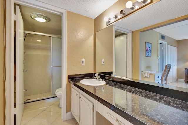 bathroom with tile patterned floors, a textured ceiling, toilet, and walk in shower