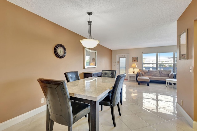 dining space with light tile patterned floors and a textured ceiling