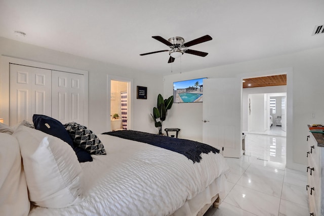 bedroom with ceiling fan, ensuite bathroom, and a closet