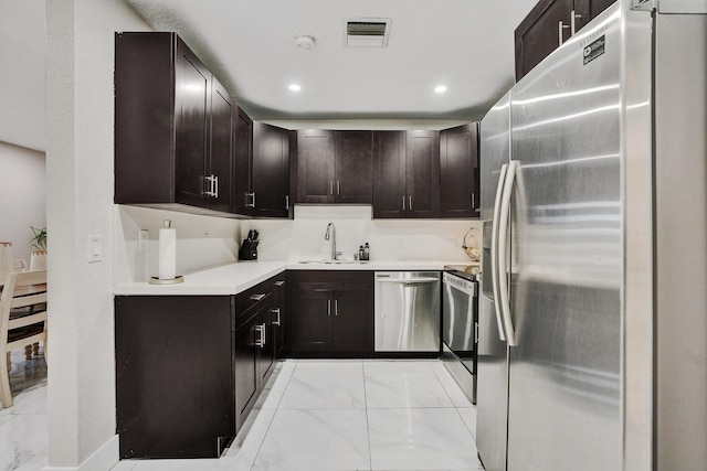 kitchen with dark brown cabinetry, sink, and appliances with stainless steel finishes