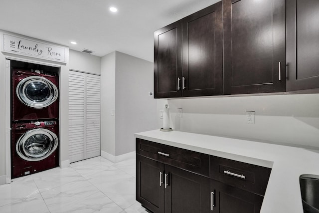 washroom with cabinets and stacked washing maching and dryer