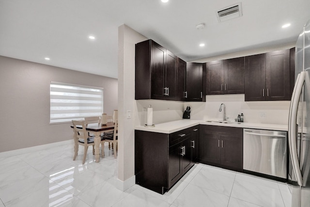 kitchen featuring dark brown cabinetry, sink, and appliances with stainless steel finishes