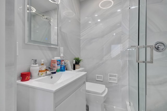 bathroom featuring vanity, toilet, and a shower with door