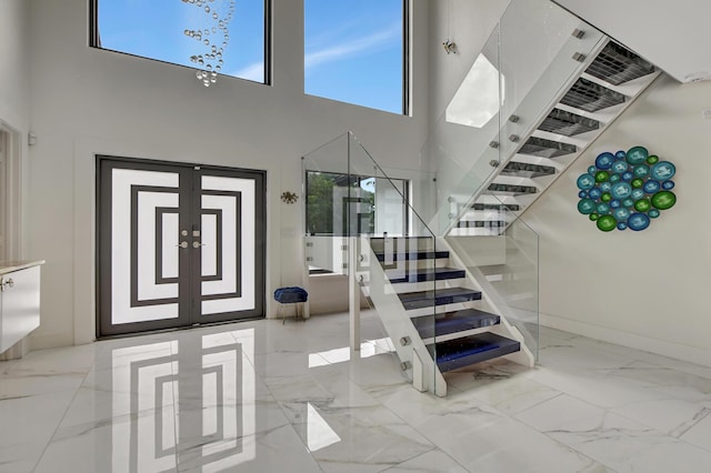 foyer entrance with french doors and a towering ceiling