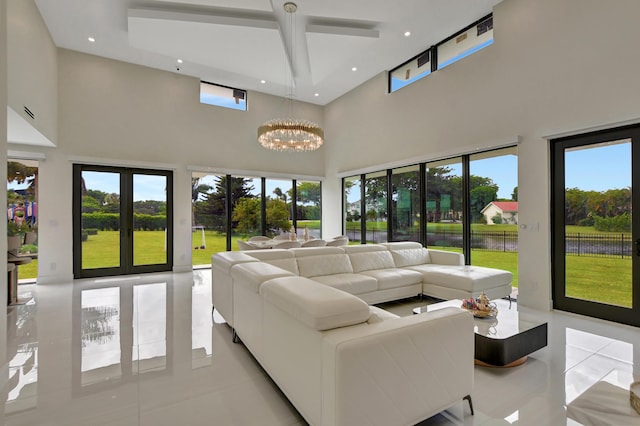 living room with a towering ceiling, light tile patterned floors, and a notable chandelier