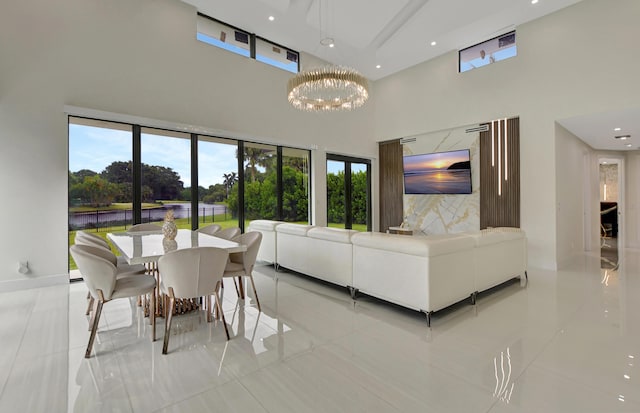 living room featuring light tile patterned flooring, a chandelier, and a high ceiling