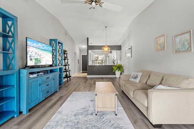 living room with light hardwood / wood-style flooring, ceiling fan, and lofted ceiling