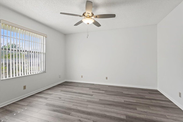 spare room with ceiling fan, wood-type flooring, and a textured ceiling