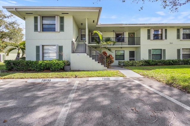 701 Sabal Ridge Cir Unit F, Palm Beach Gardens, FL 33418 - view of front facade featuring stairs, stucco siding, and uncovered parking
