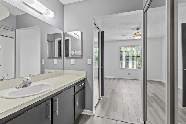 bathroom featuring ceiling fan, vanity, a textured ceiling, and hardwood / wood-style flooring