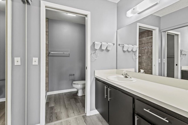 bathroom with hardwood / wood-style floors, vanity, and toilet