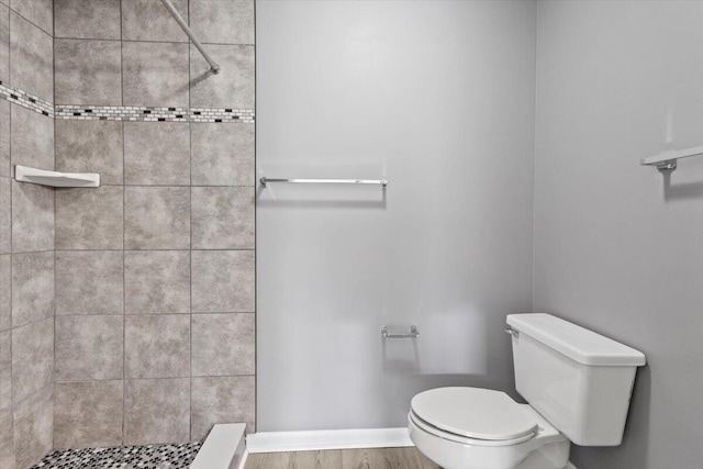 bathroom featuring a tile shower and toilet