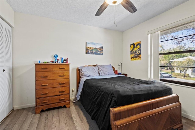 bedroom featuring ceiling fan, a closet, a textured ceiling, and hardwood / wood-style flooring