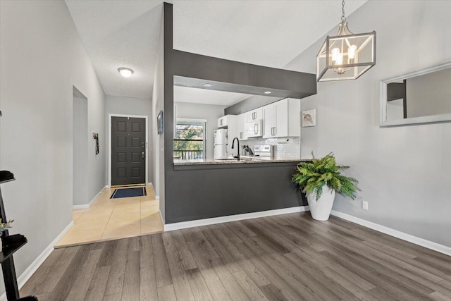 701 Sabal Ridge Cir Unit F, Palm Beach Gardens, FL 33418 - foyer with baseboards, wood finished floors, and a chandelier