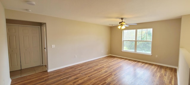 unfurnished room with dark hardwood / wood-style flooring and ceiling fan