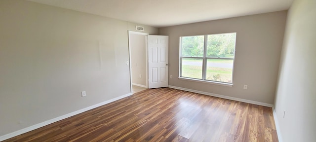 empty room with dark hardwood / wood-style flooring