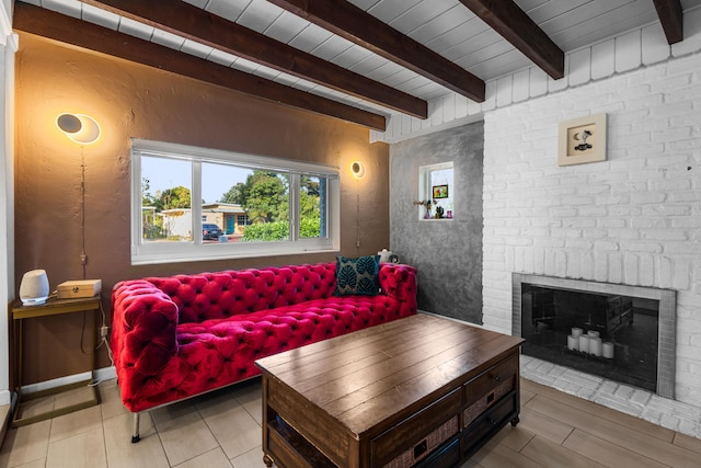 living room featuring beamed ceiling, a brick fireplace, and wooden ceiling