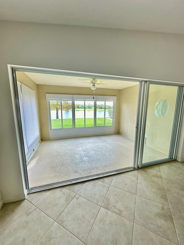 tiled empty room featuring ceiling fan