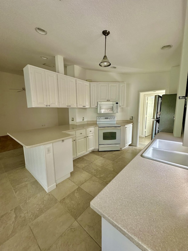 kitchen with electric range oven, ceiling fan, sink, white cabinets, and hanging light fixtures