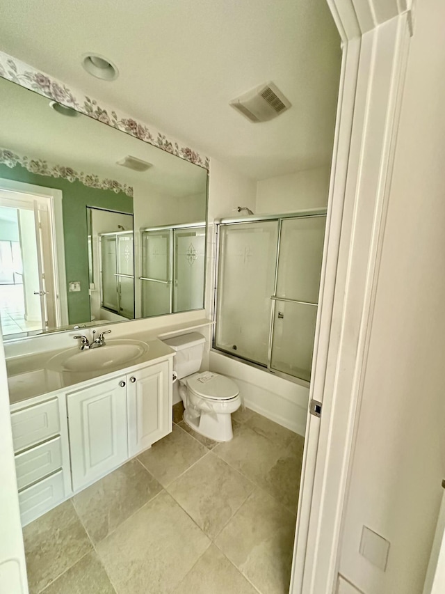 full bathroom with combined bath / shower with glass door, tile patterned floors, vanity, and toilet