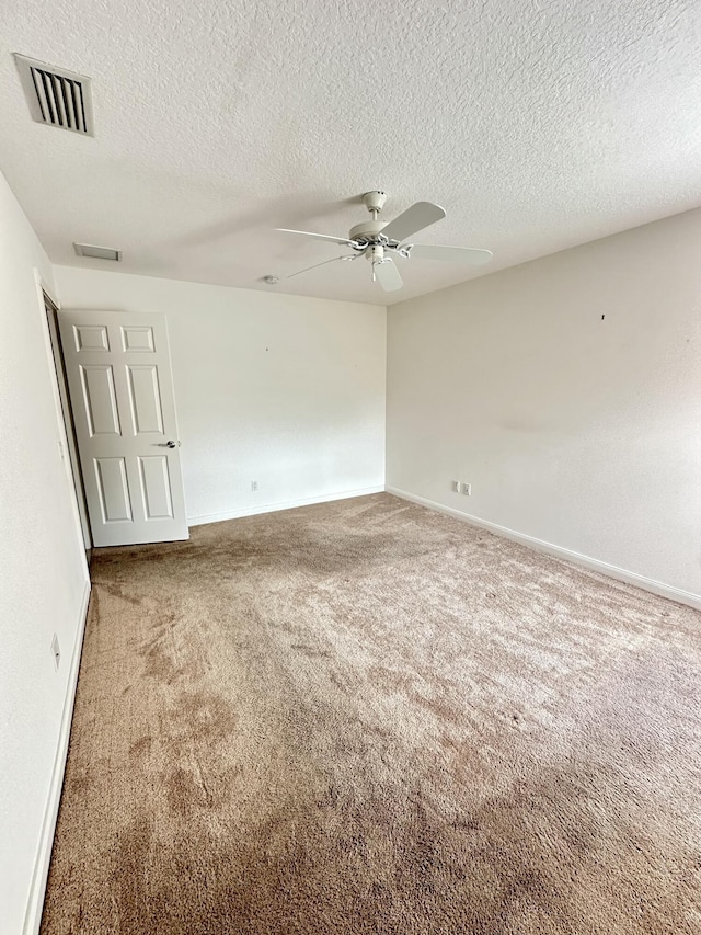 carpeted spare room with ceiling fan and a textured ceiling