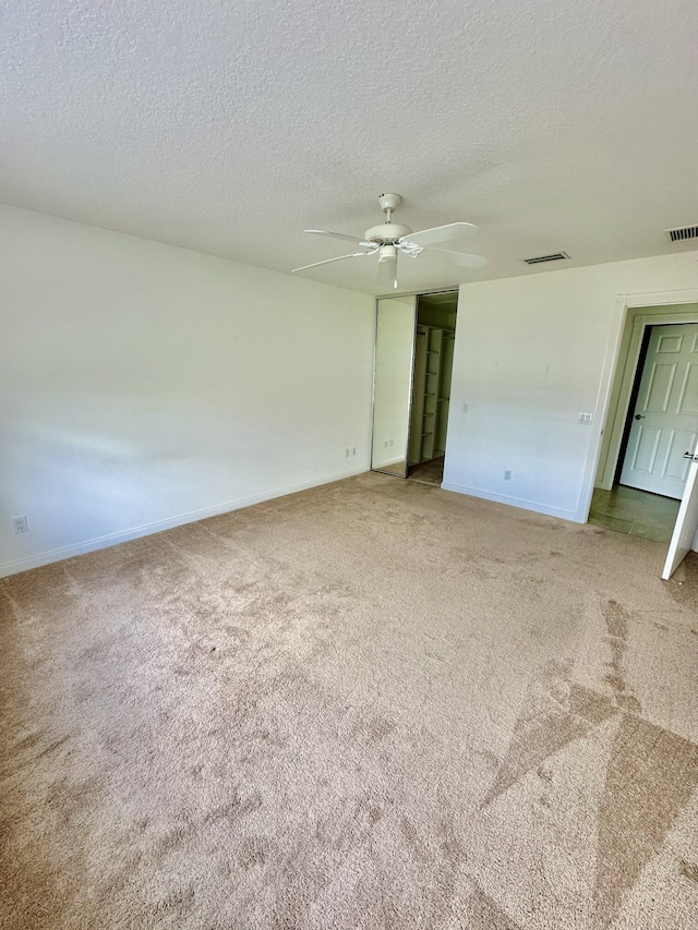 unfurnished room featuring carpet and a textured ceiling