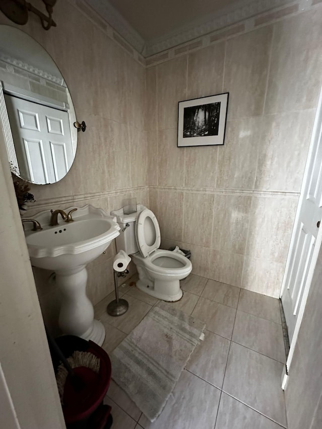 bathroom with tile patterned flooring, toilet, and tile walls