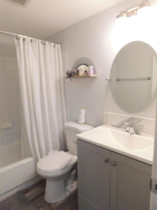 full bathroom with shower / tub combo with curtain, vanity, wood-type flooring, and toilet