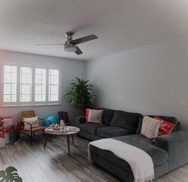 living room with hardwood / wood-style flooring, ceiling fan, and a textured ceiling