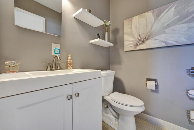 bathroom with tile patterned flooring, vanity, and toilet