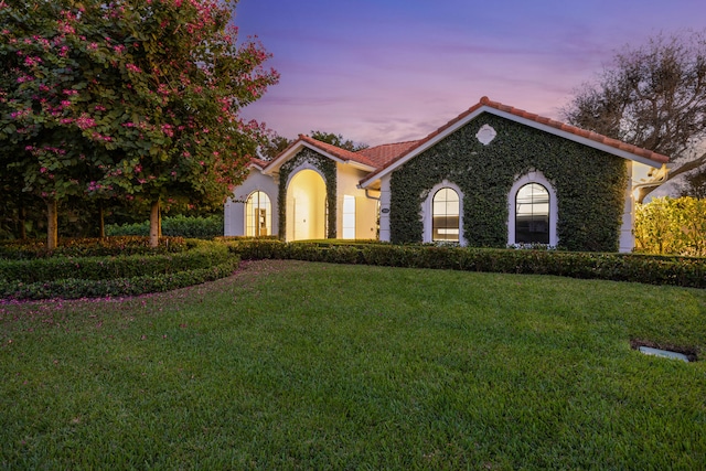 mediterranean / spanish-style home with a lawn