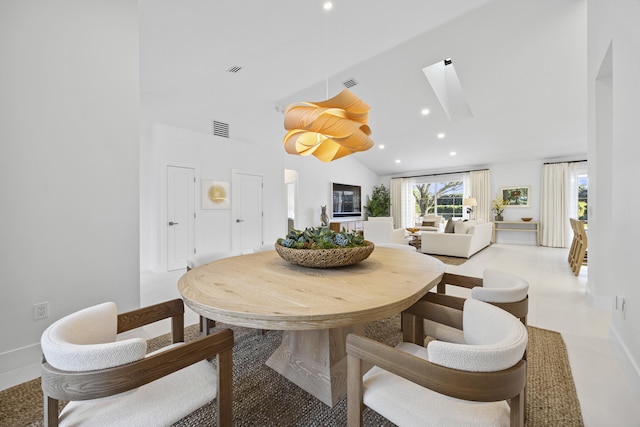 dining area featuring lofted ceiling with skylight