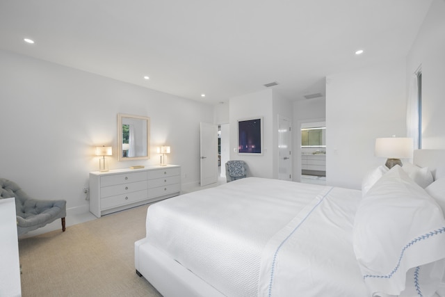 bedroom with light colored carpet and ensuite bathroom