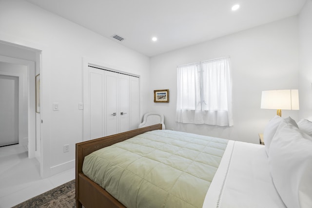 bedroom with tile patterned flooring and a closet