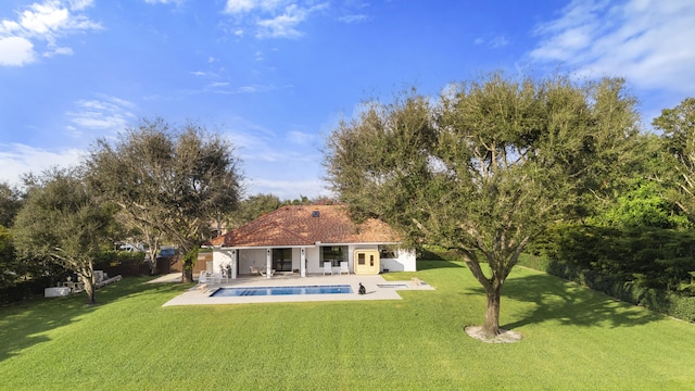 rear view of house featuring a lawn and a patio