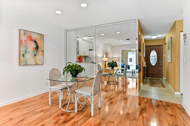 dining room with a textured ceiling and light wood-type flooring