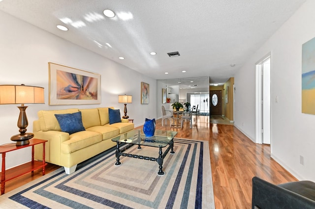 living room featuring light hardwood / wood-style floors and a textured ceiling