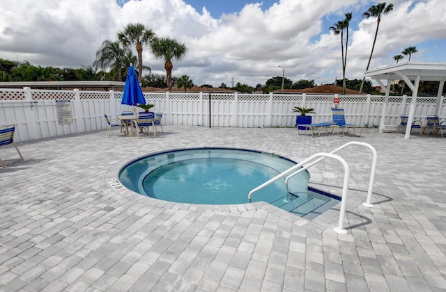 view of swimming pool with a patio and a hot tub