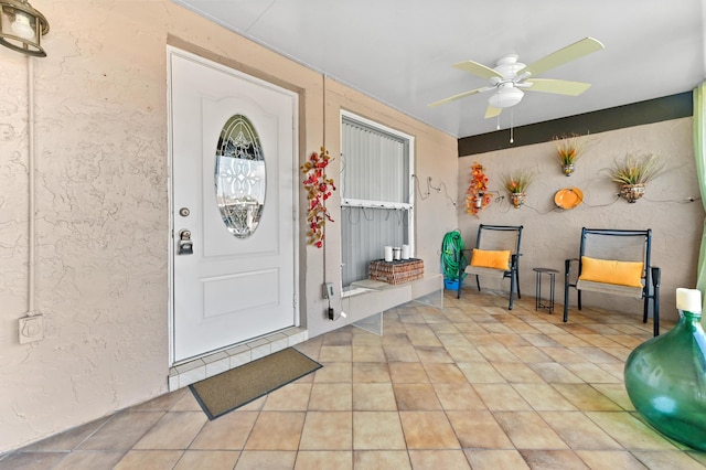 property entrance featuring a patio area and ceiling fan