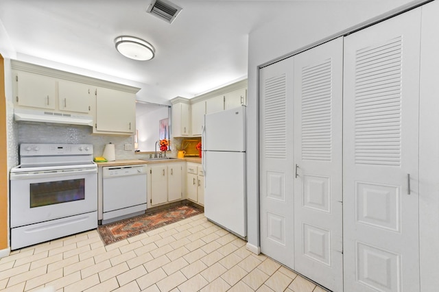 kitchen with cream cabinetry, decorative backsplash, white appliances, and sink