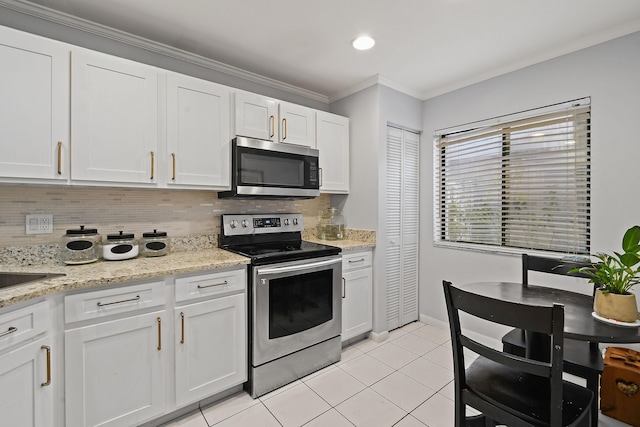 kitchen with light tile patterned floors, crown molding, white cabinetry, backsplash, and stainless steel appliances