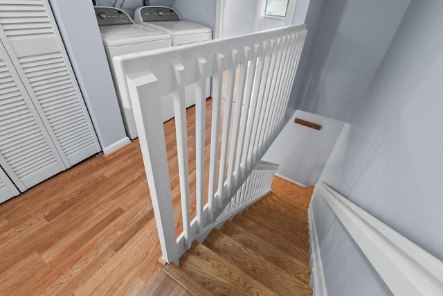 staircase with wood-type flooring and separate washer and dryer