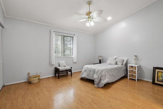 bedroom with crown molding, light hardwood / wood-style flooring, and ceiling fan