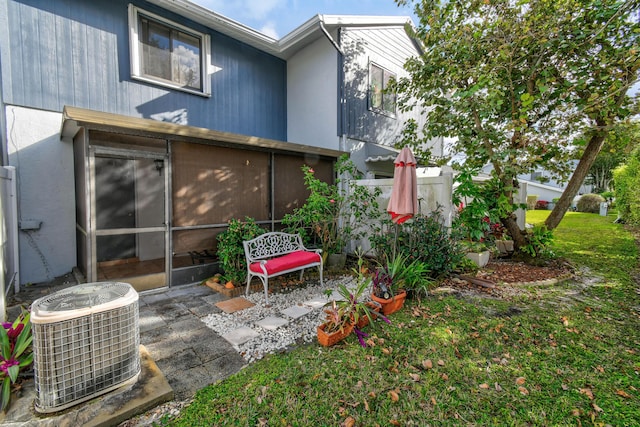 rear view of property featuring a patio, central AC unit, and a lawn