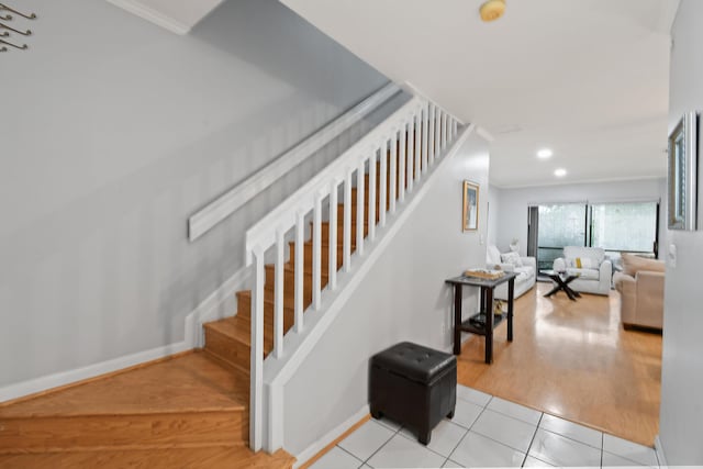 stairs with tile patterned flooring and ornamental molding