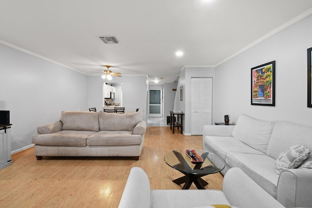 living room with crown molding, ceiling fan, and light wood-type flooring