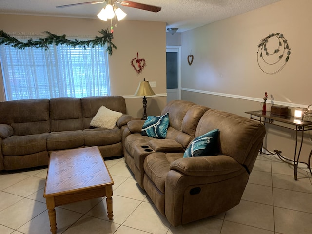 tiled living room with ceiling fan and a textured ceiling