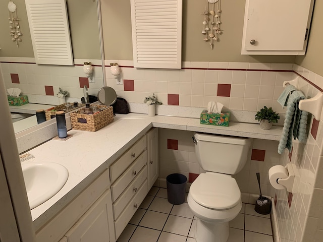 bathroom featuring toilet, vanity, tile patterned floors, and tile walls