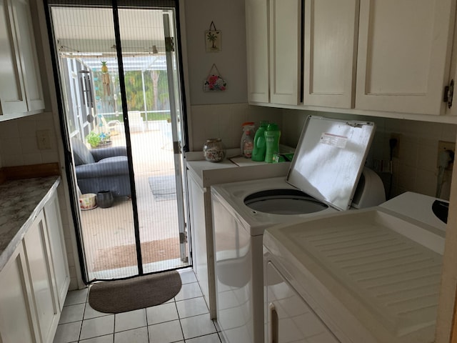 washroom featuring cabinets, separate washer and dryer, and light tile patterned floors